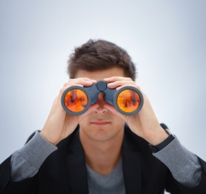 Closeup portrait of young man using binoculars